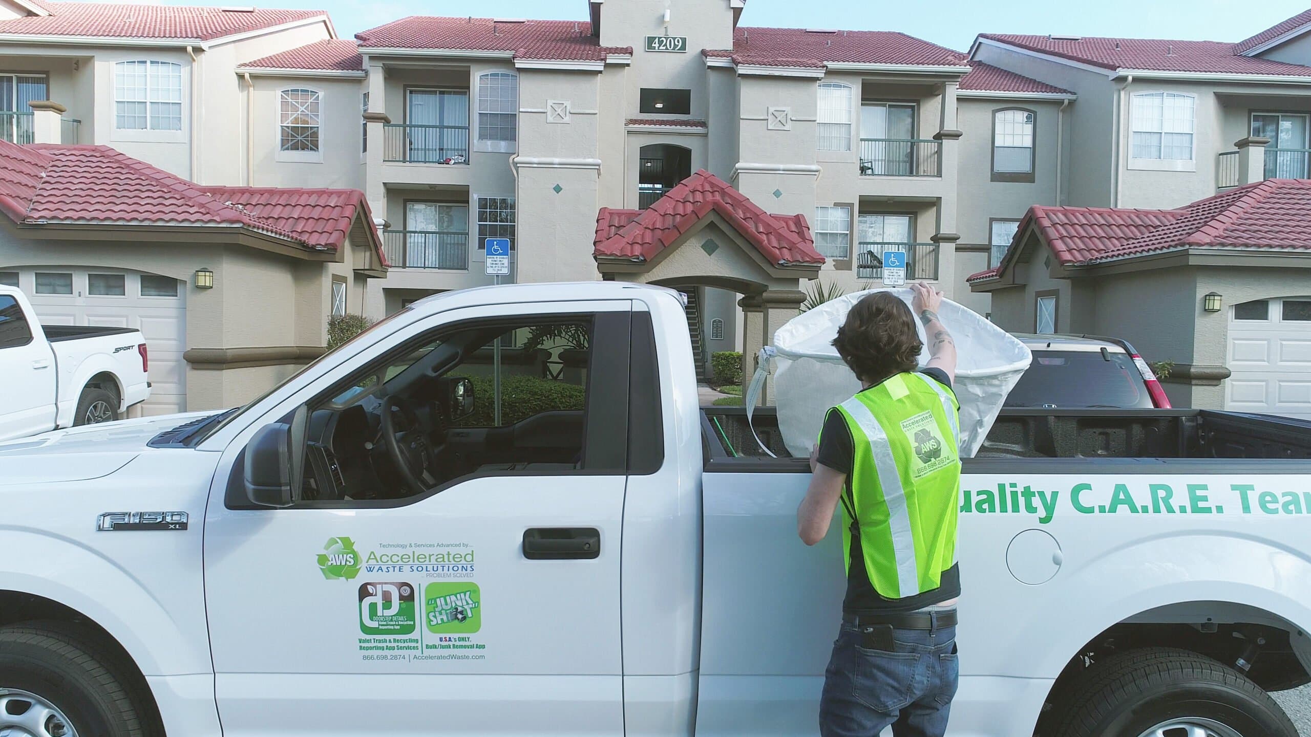 Valet trash porters collecting doorstep trash at an apartment community